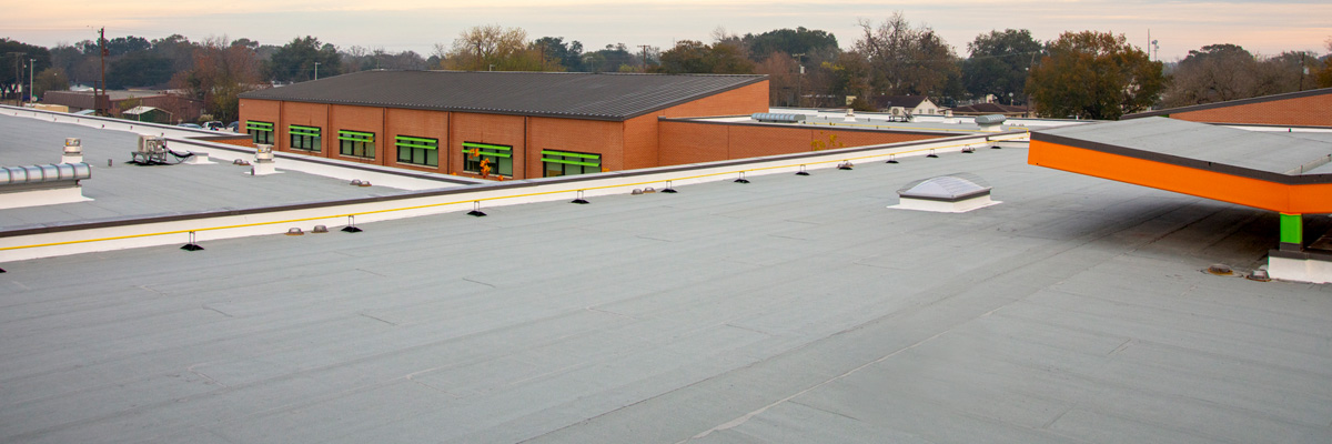 A gray building roof showcasing base sheet roofing material from Garland.