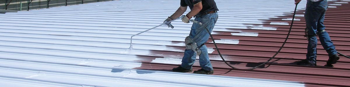 Roof Restoration Coatings Workers apply a thin white coat of roof coating to restore a roof.