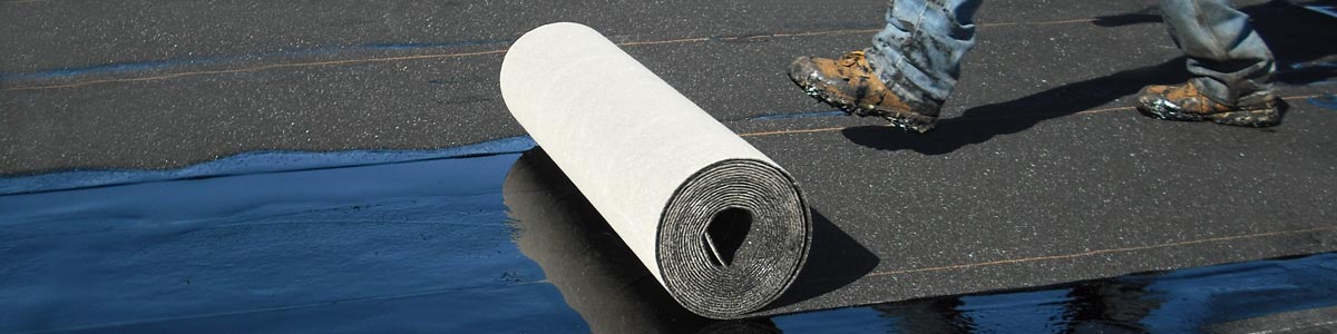 Base and Felt Sheets A worker unrolls base sheet roofing with his boot.